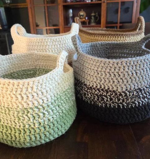Handmade crochet storage baskets in earth tones on a wooden table