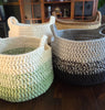 Handmade crochet baskets in neutral and green tones on a wooden table