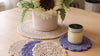 Handmade crochet coasters and placemat with sunflower decor and candle on wooden table