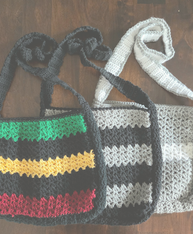 Handmade crochet crossbody bags with colorful striped patterns on a wooden surface
