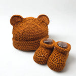 Handmade crochet baby bear hat and booties set in warm rust color, perfect cozy newborn gift