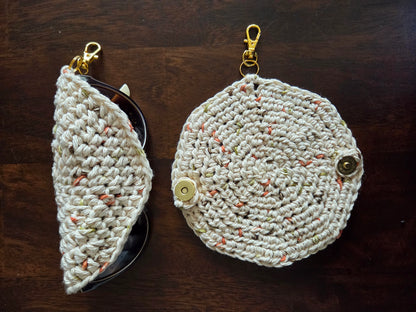 Handmade crochet eyeglass case with clasp, beige and speckled yarn, on wood surface