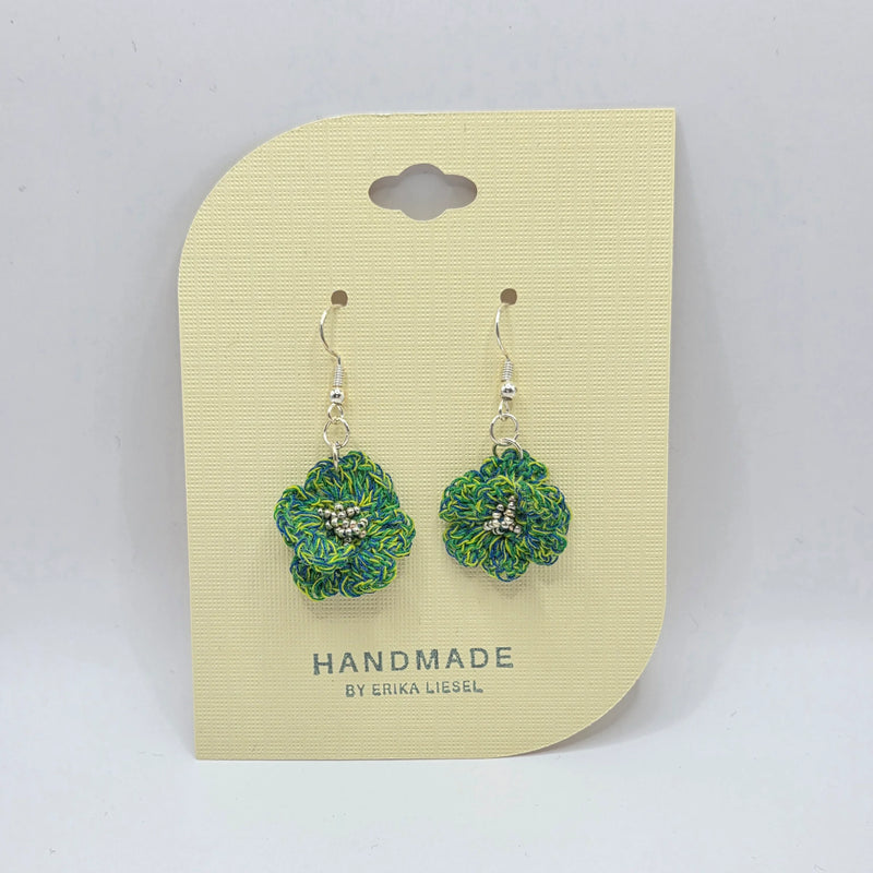 Handmade crochet flower earrings with green and blue yarn, featuring silver beads and hooks