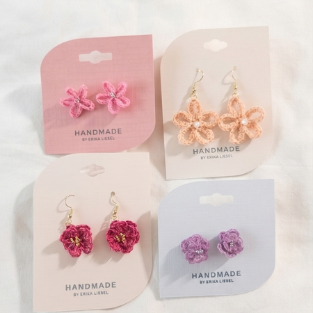 Handmade crochet flower earrings in pink, peach, red, and purple with pearl centers