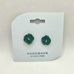 Handmade crochet flower earrings in green and blue, cozy artisan jewelry on display card