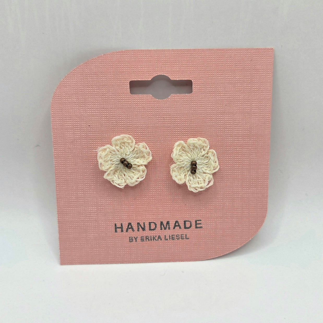 Handmade crochet flower earrings on pink card, cozy and creative gift