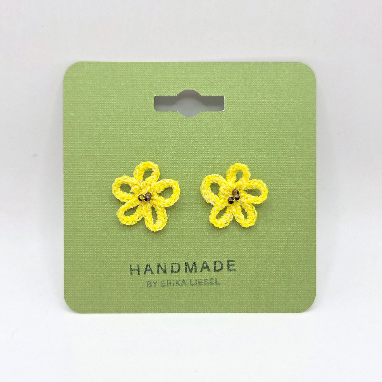 Handmade yellow crochet flower earrings on green card, cozy and creative gift