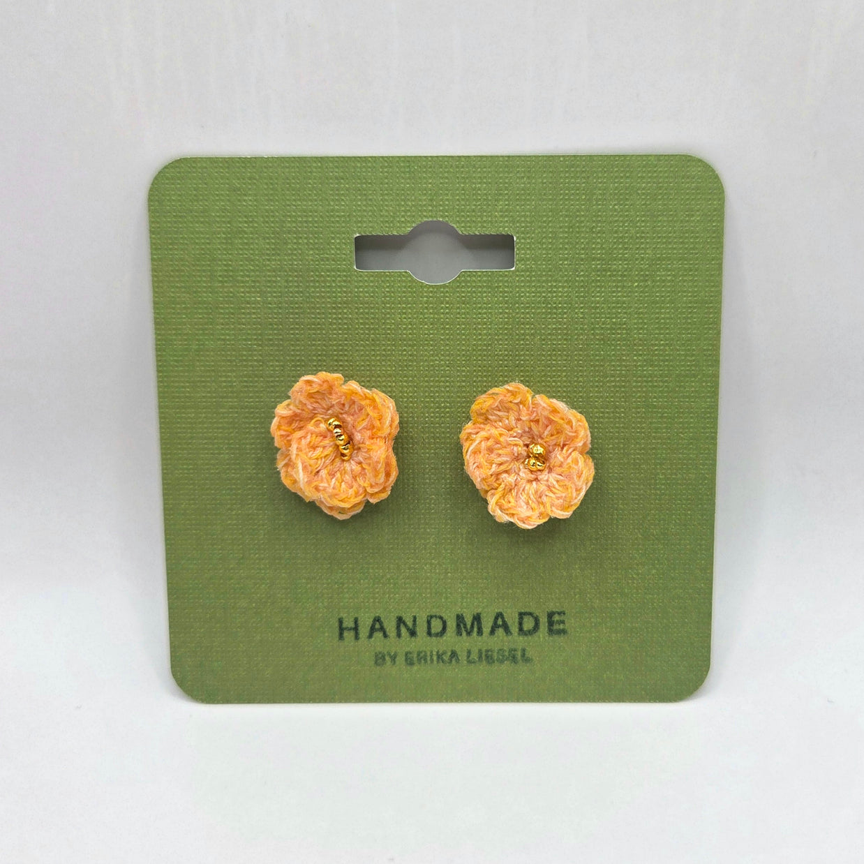 Handmade crochet flower earrings with gold centers on green card