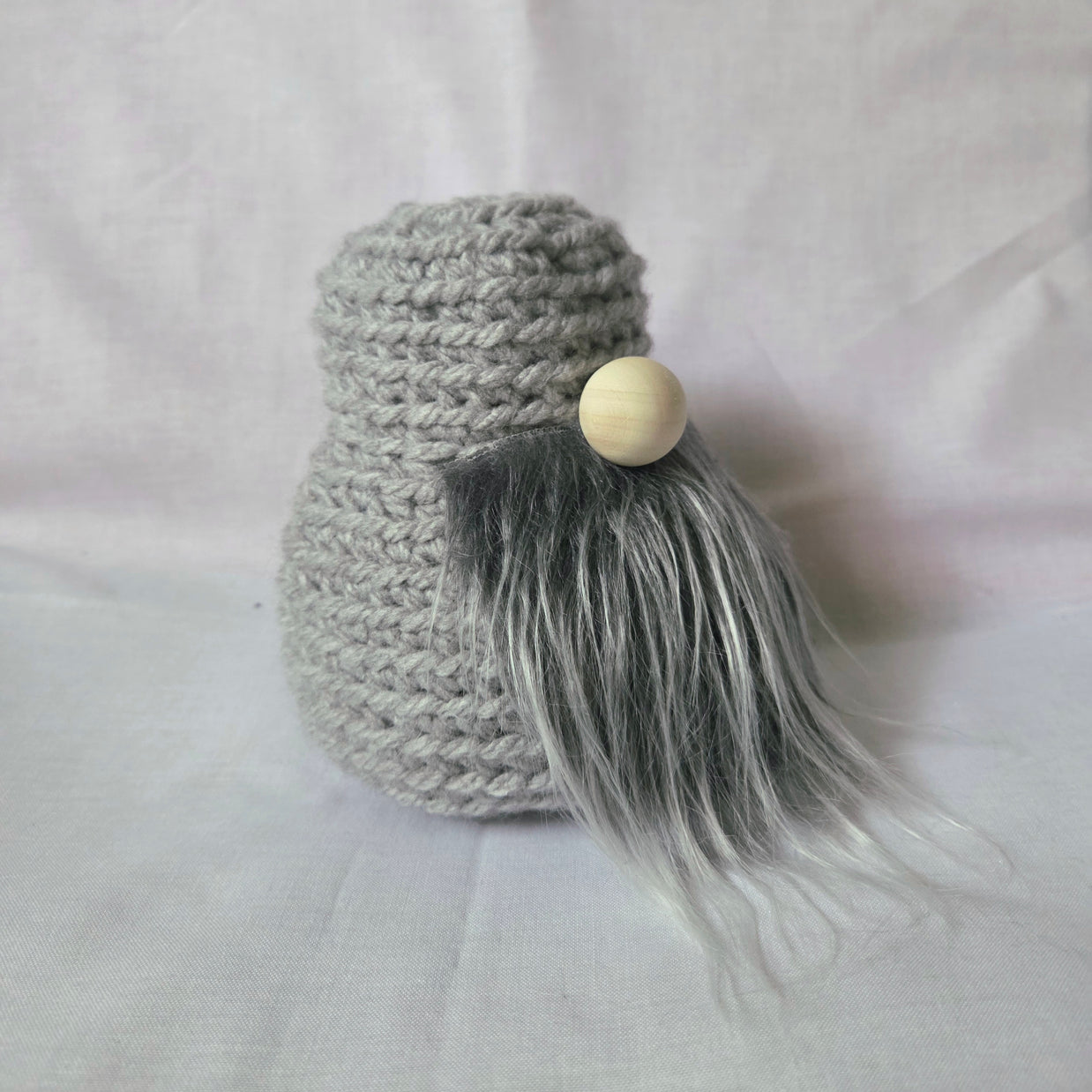Gray crochet gnome with wooden nose and fluffy beard, handmade cozy decor