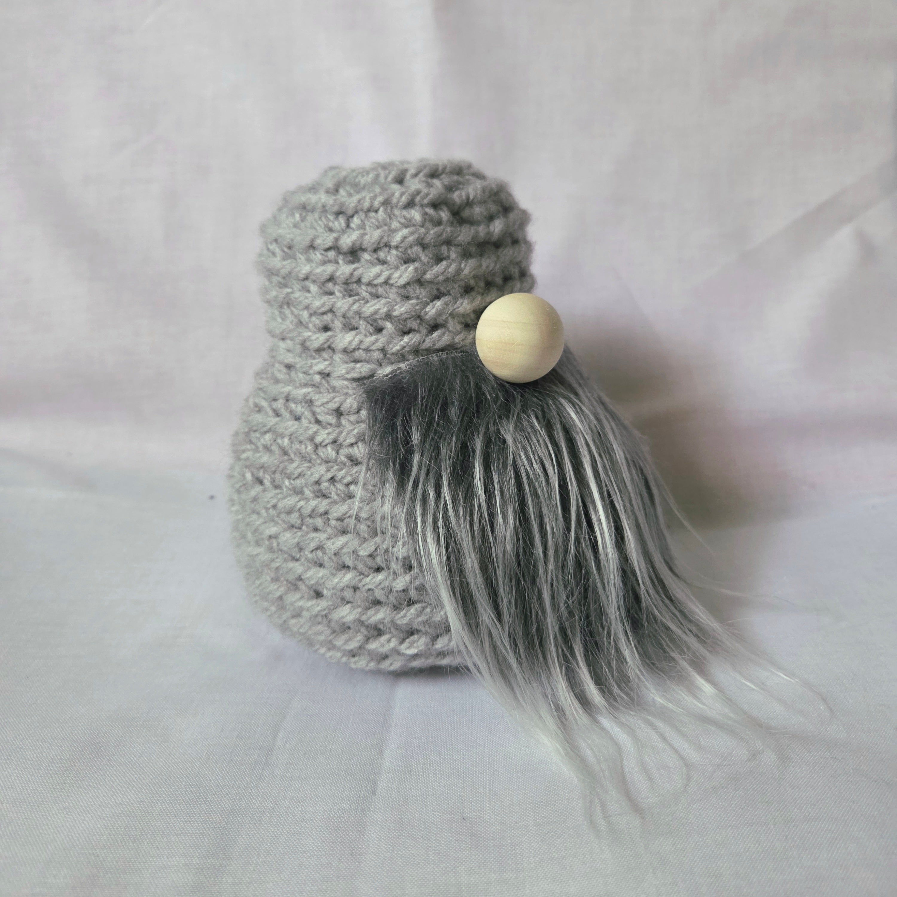 Gray crochet gnome with wooden nose and fluffy beard, handmade cozy decor