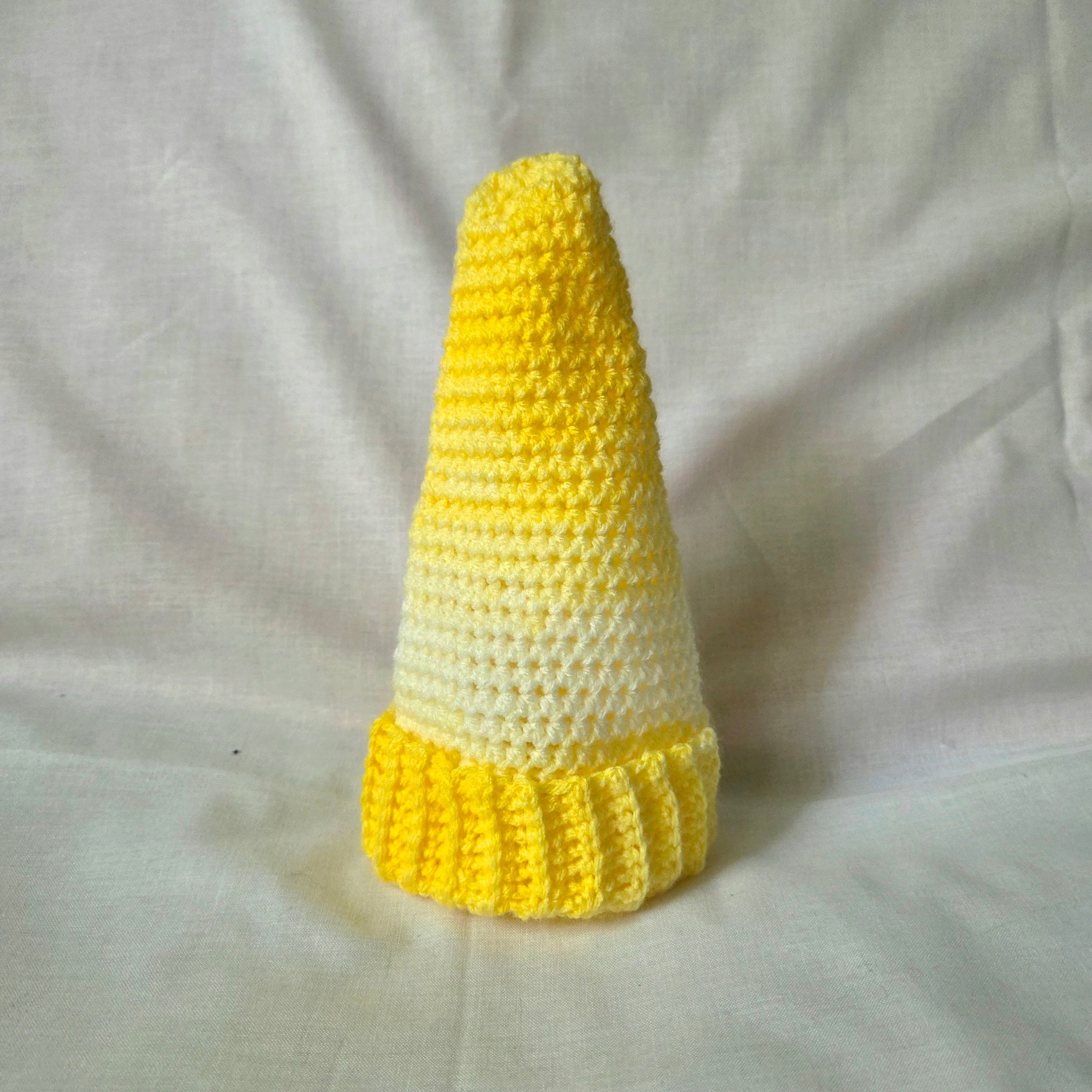 Handmade yellow and white crocheted cone with ruffled base, cozy decorative piece