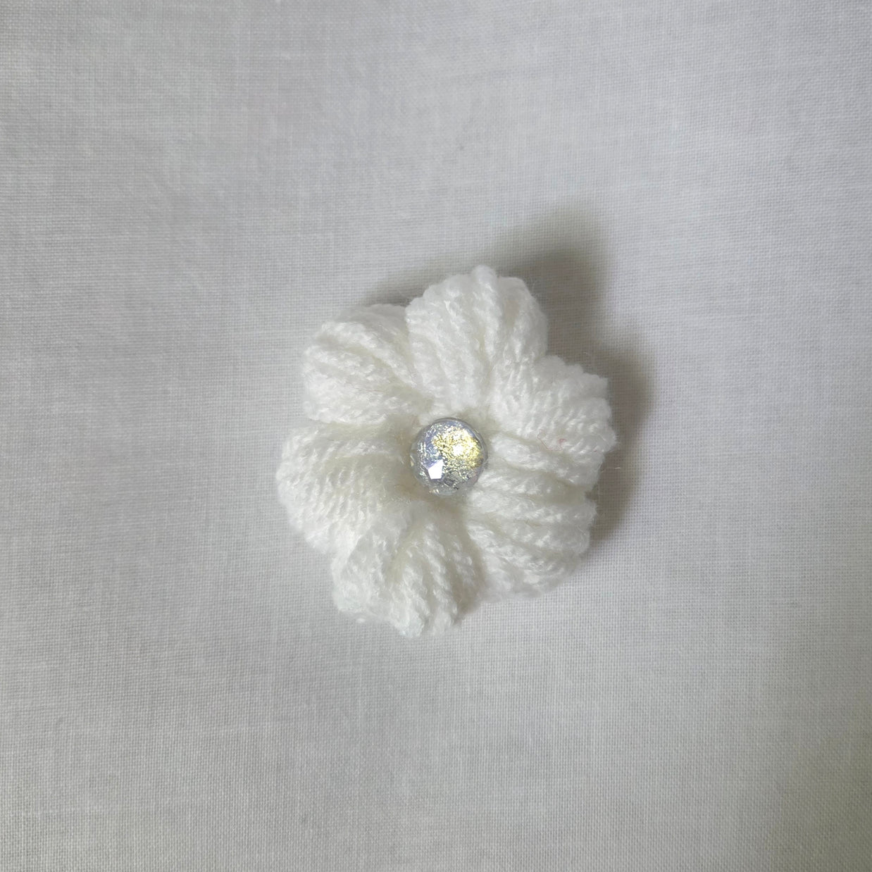 Handmade white crochet flower with sparkling center, cozy and creative design