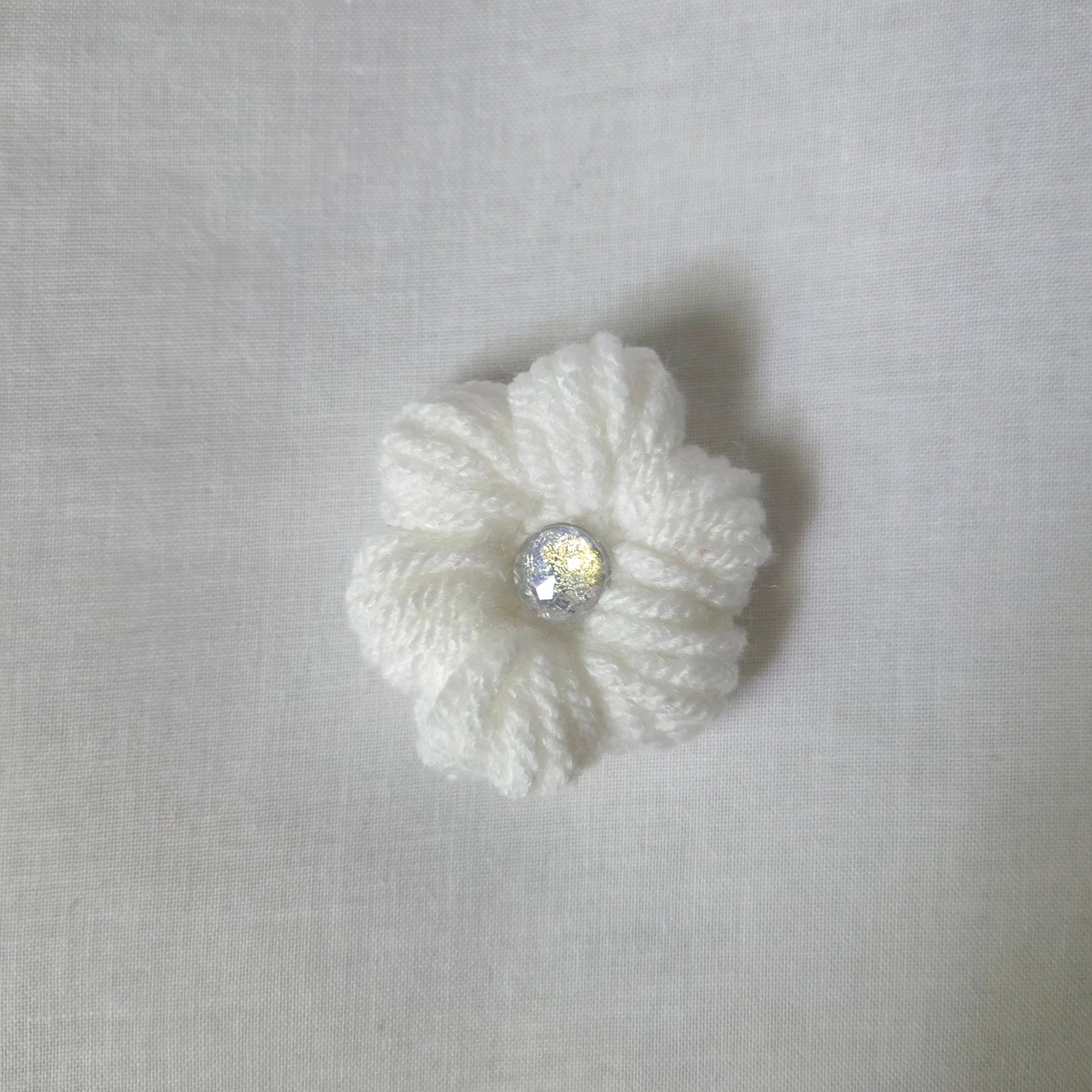 Handmade white crochet flower with sparkling center, cozy and creative design