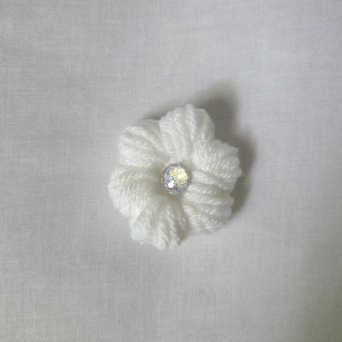 Handmade white crochet flower with sparkling center, cozy and creative design