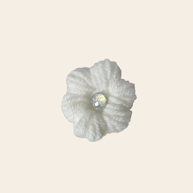 Handmade white crochet flower with sparkling center, cozy and creative design
