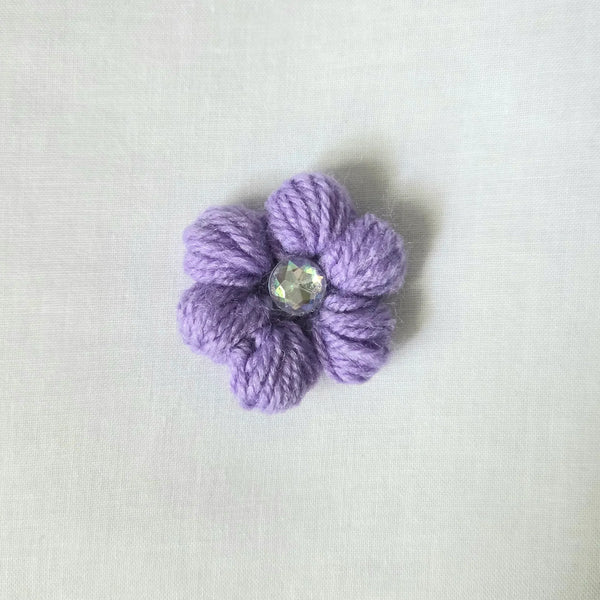Handmade lavender crochet flower pin with sparkling gem center, cozy craft gift