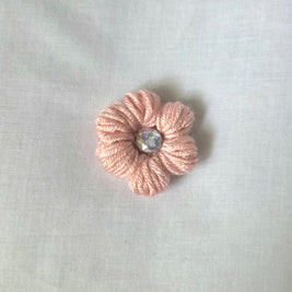 Handmade pink crochet flower pin with iridescent gem center, cozy craft gift