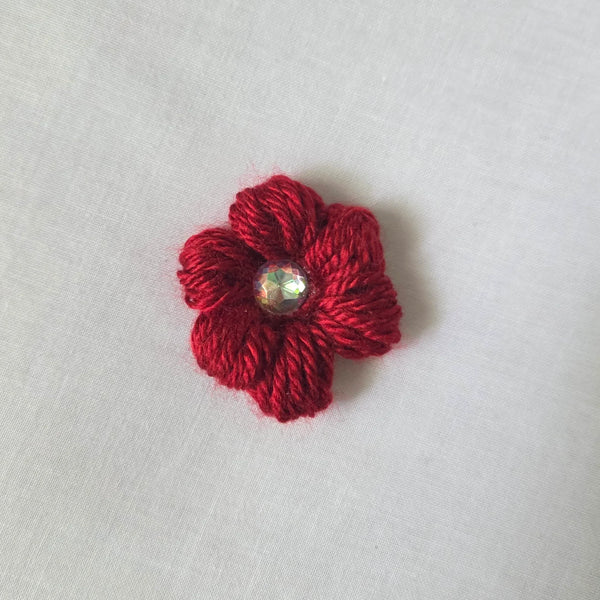 Red crochet flower brooch with sparkling gem center, handmade for cozy, creative gifts