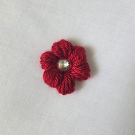 Red crochet flower brooch with sparkling gem center, handmade for cozy, creative gifts