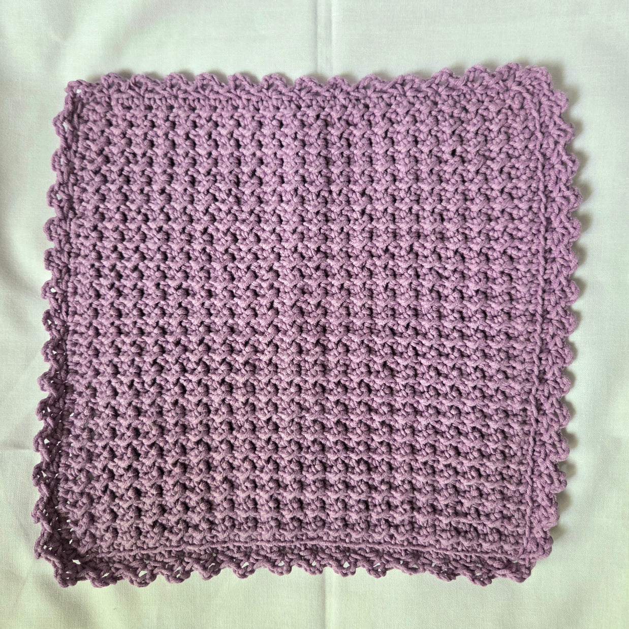 Handmade lavender crochet dishcloth with scalloped edge, cozy kitchen textile