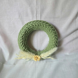 Handmade green crochet wreath with dried flowers and feathers, cozy home decor