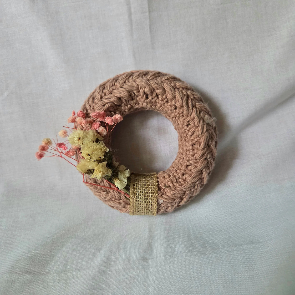 Handmade crochet wreath with dried flowers and burlap ribbon, cozy home decor