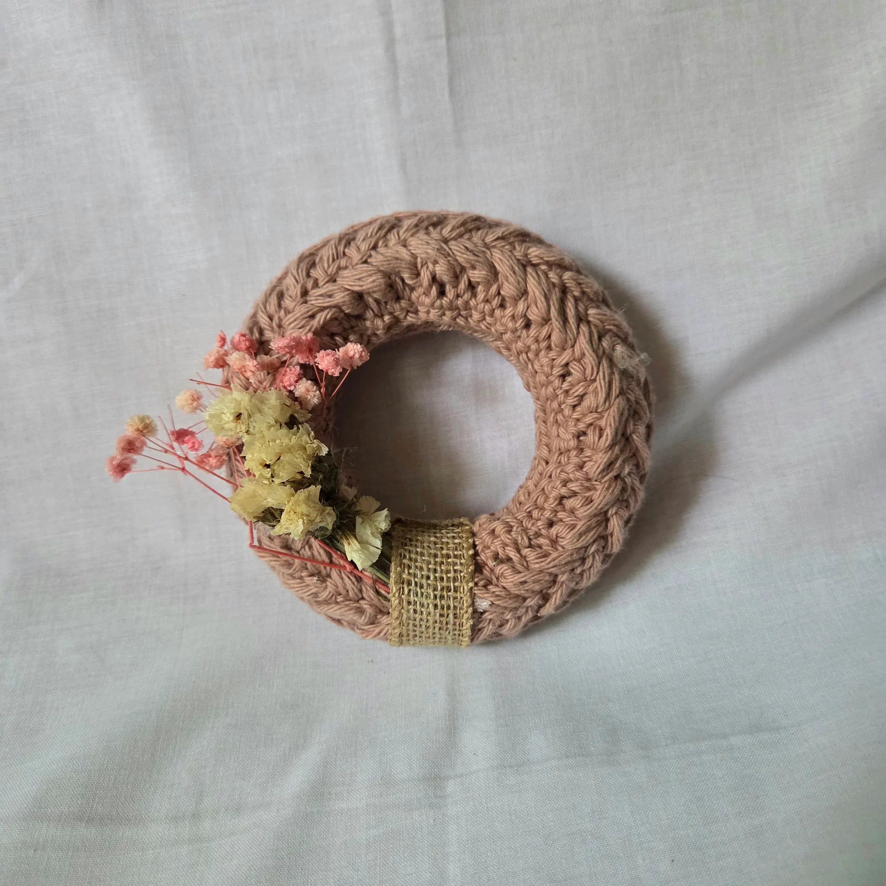 Handmade crochet wreath with dried flowers and burlap ribbon, cozy home decor