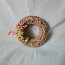Handmade crochet wreath with dried flowers and burlap ribbon, cozy home decor
