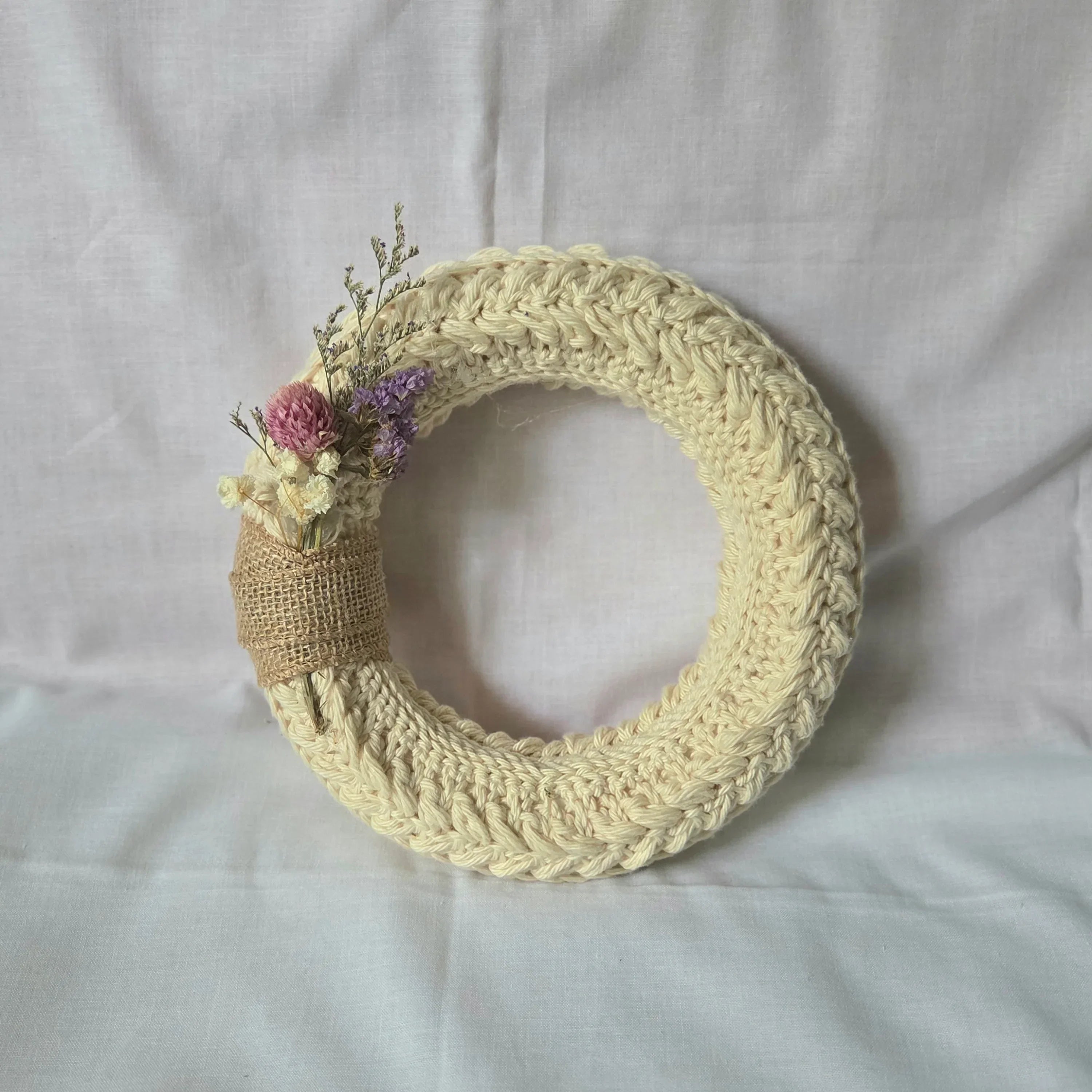 Handmade crochet wreath with dried flowers and burlap accent, cozy home decor