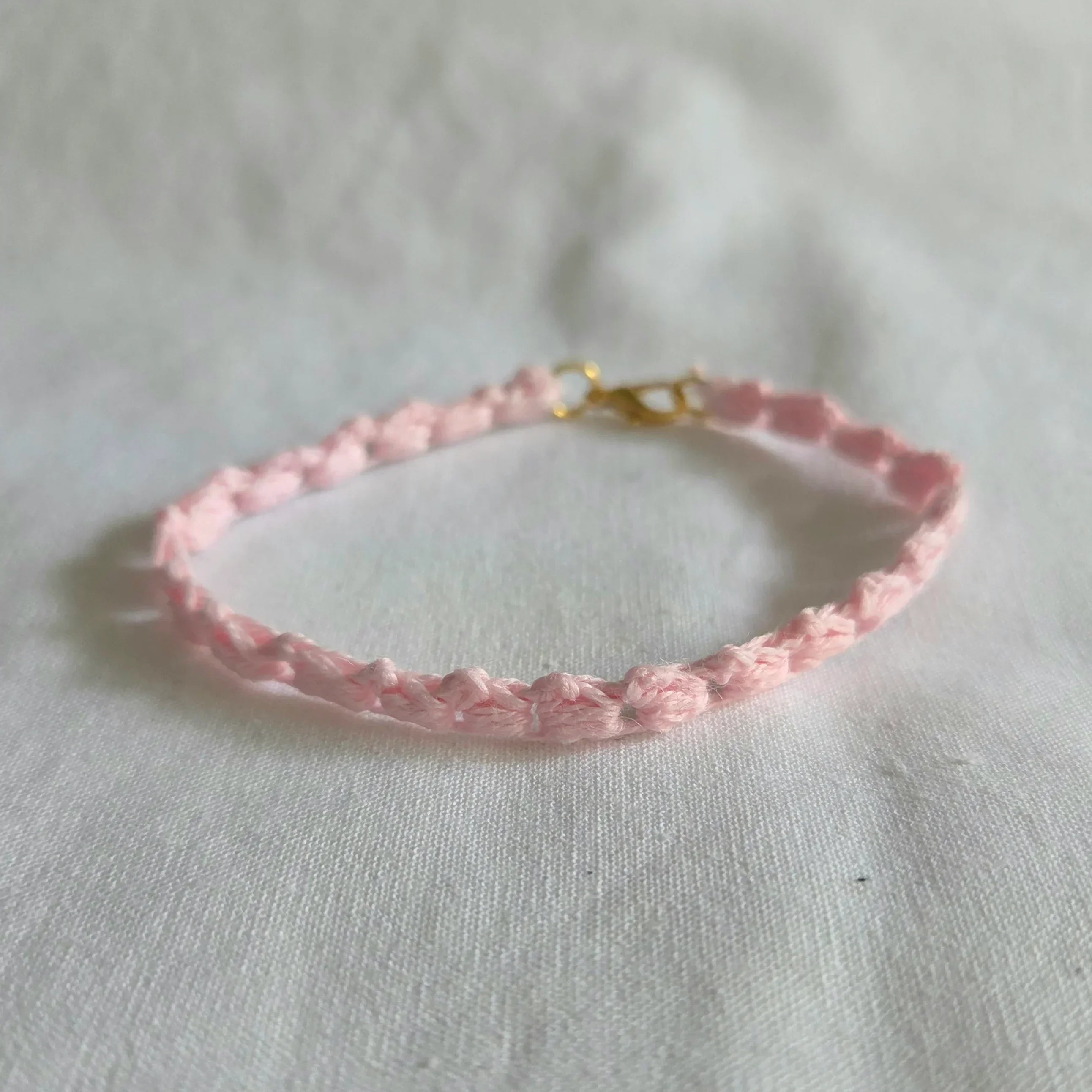 Delicate pink crochet bracelet with gold clasp, handmade for everyday comfort and style.