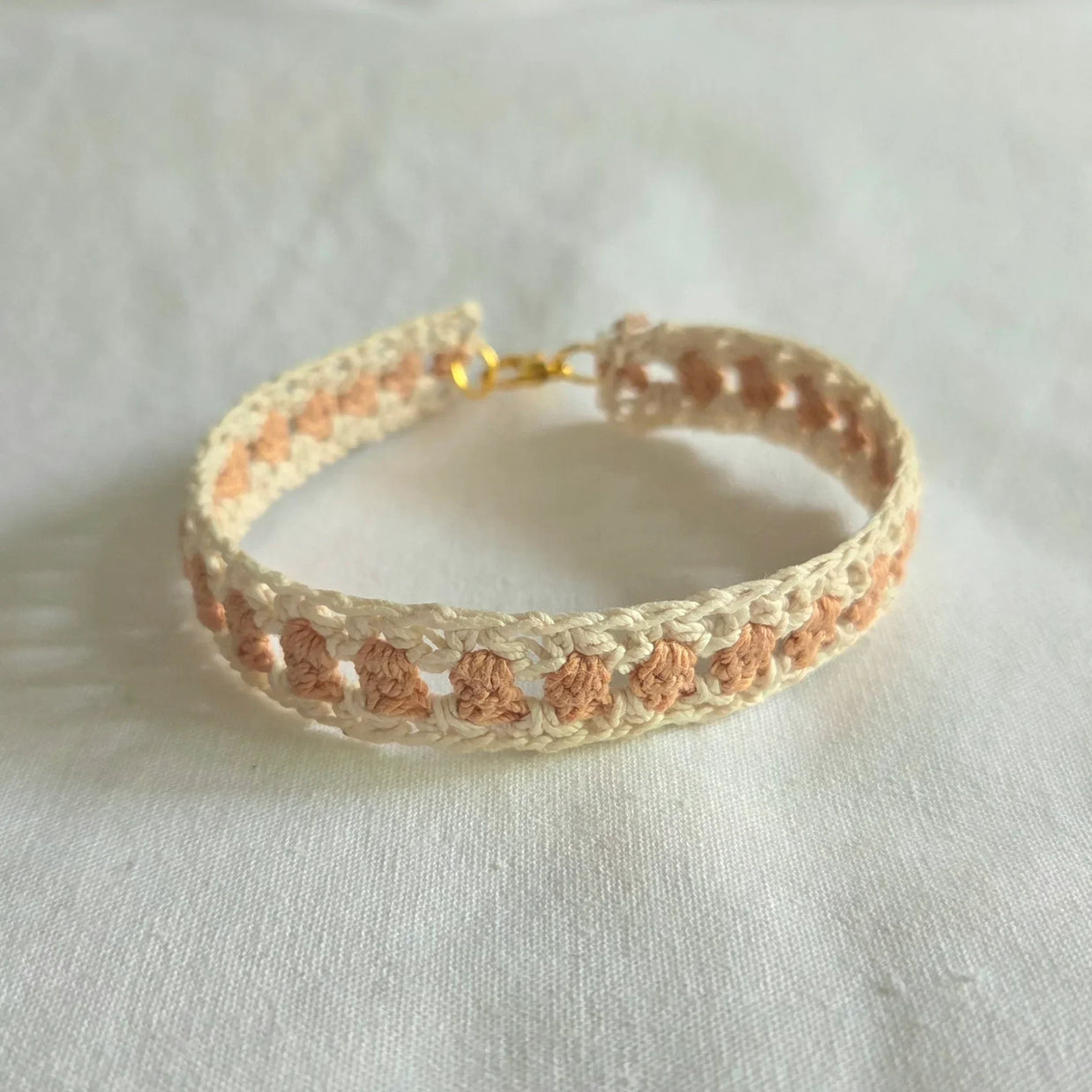 Handmade crochet bracelet with cream and peach pattern, gold clasp, cozy boho accessory