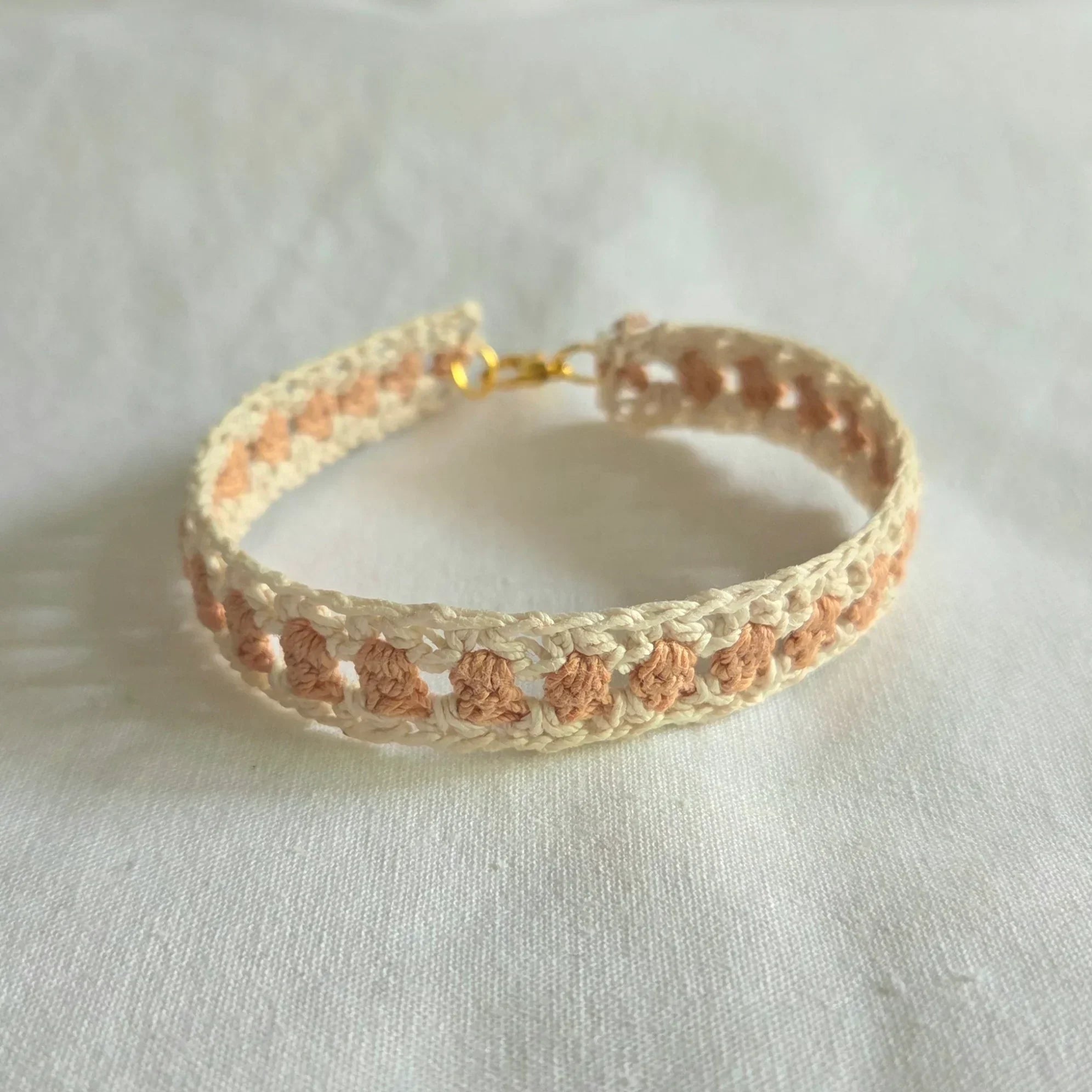 Handmade crochet bracelet with cream and peach pattern, gold clasp, cozy boho accessory