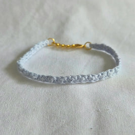Delicate light blue crocheted bracelet with gold clasp, handmade for everyday comfort and style.