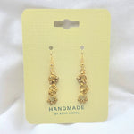 Handmade gold chain link earrings with beads on pale yellow card, artisan jewelry gift