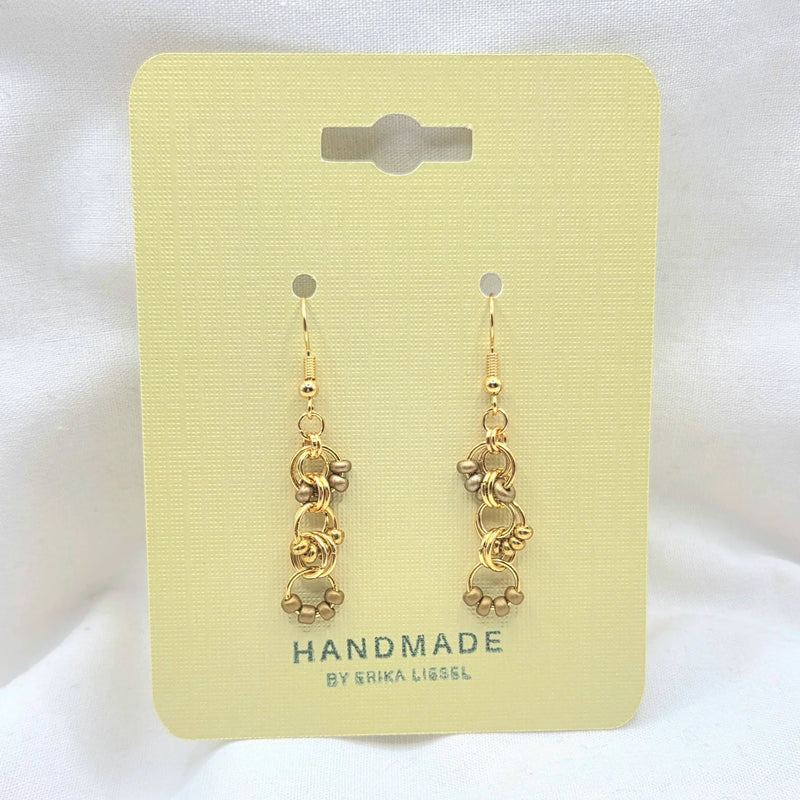 Handmade gold chain link earrings with beads on pale yellow card, artisan jewelry gift