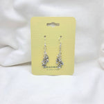 Handmade silver chainmaille earrings with gray beads on yellow card, perfect for cozy gifting