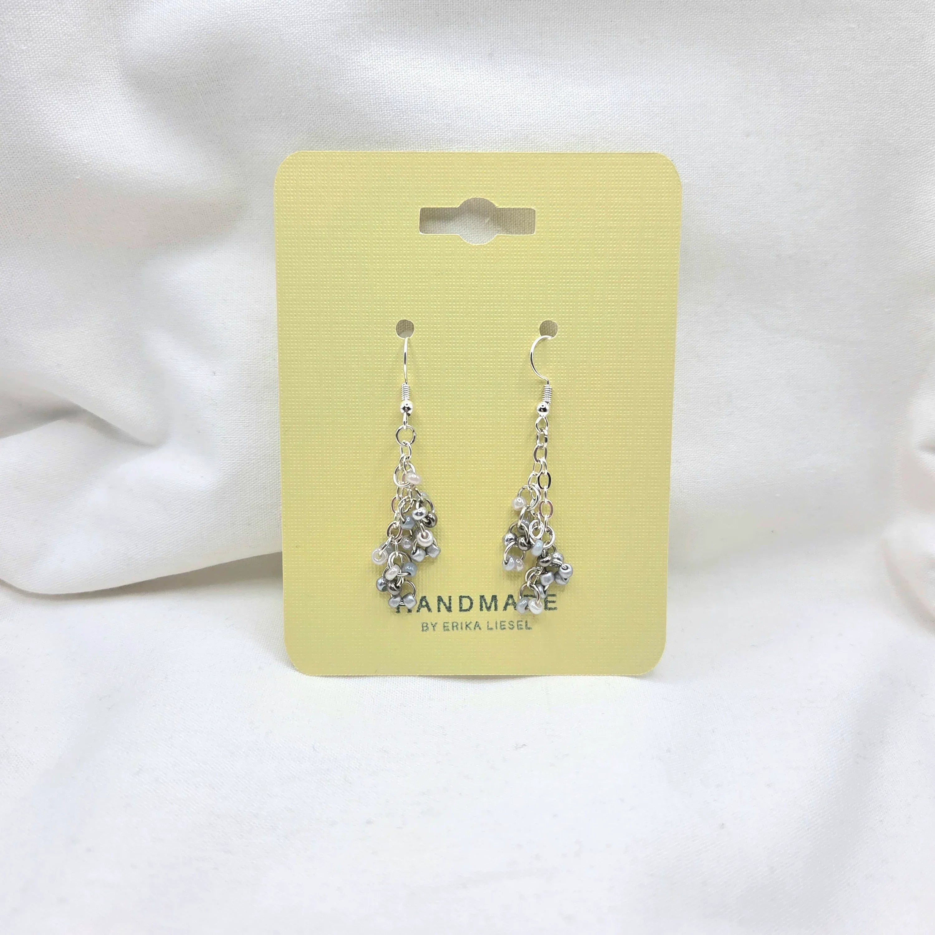 Handmade silver chain and bead dangle earrings on yellow card, perfect for cozy gifting