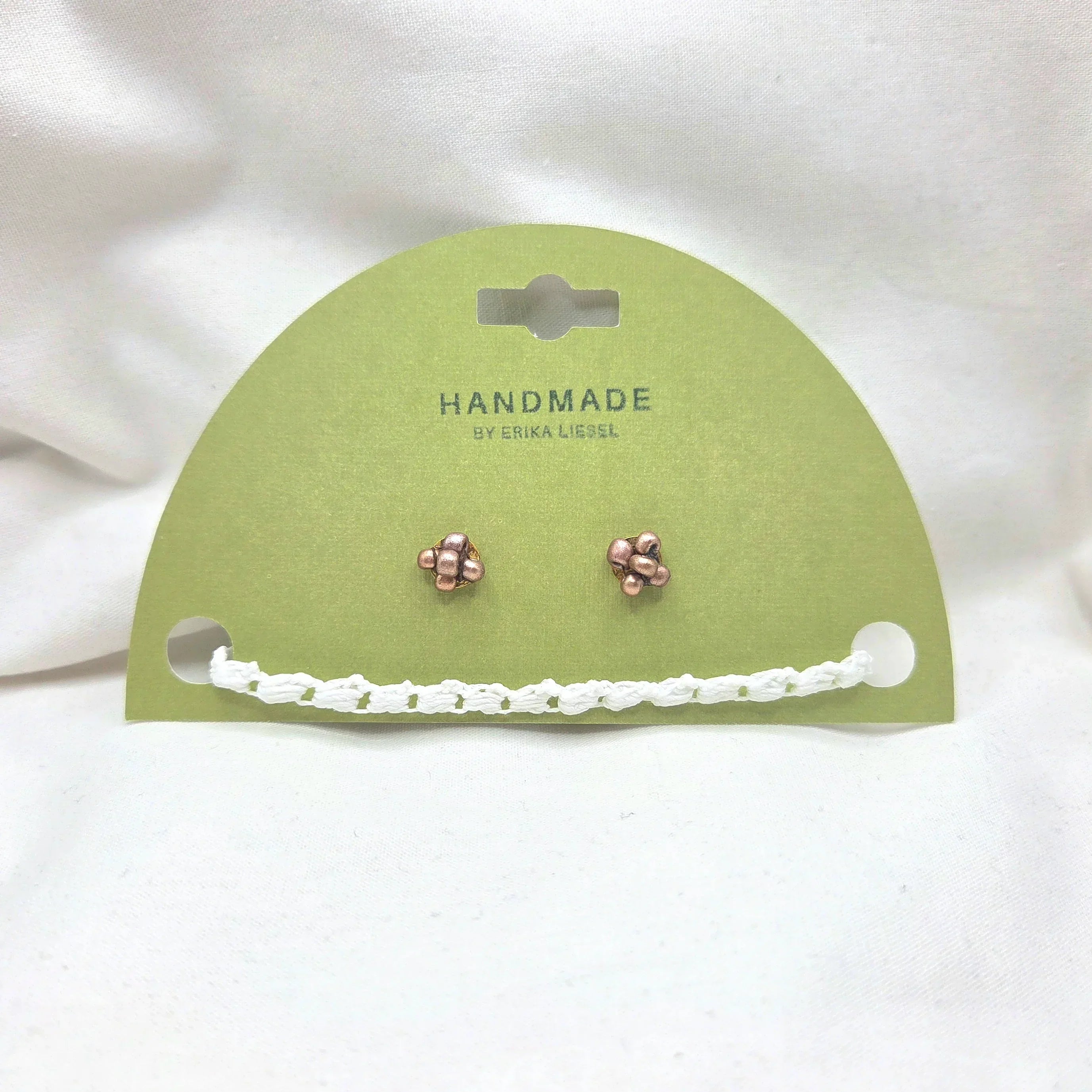 Handmade copper stud earrings with white crochet chain on green card, cozy artisan jewelry gift