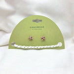 Handmade copper stud earrings with white crochet chain on green card, cozy artisan jewelry gift