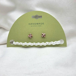 Handmade copper flower stud earrings with white crochet trim on green card