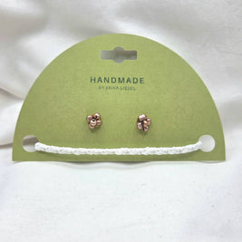 Handmade copper jingle bell earrings on green card with white crochet trim, cozy holiday gift