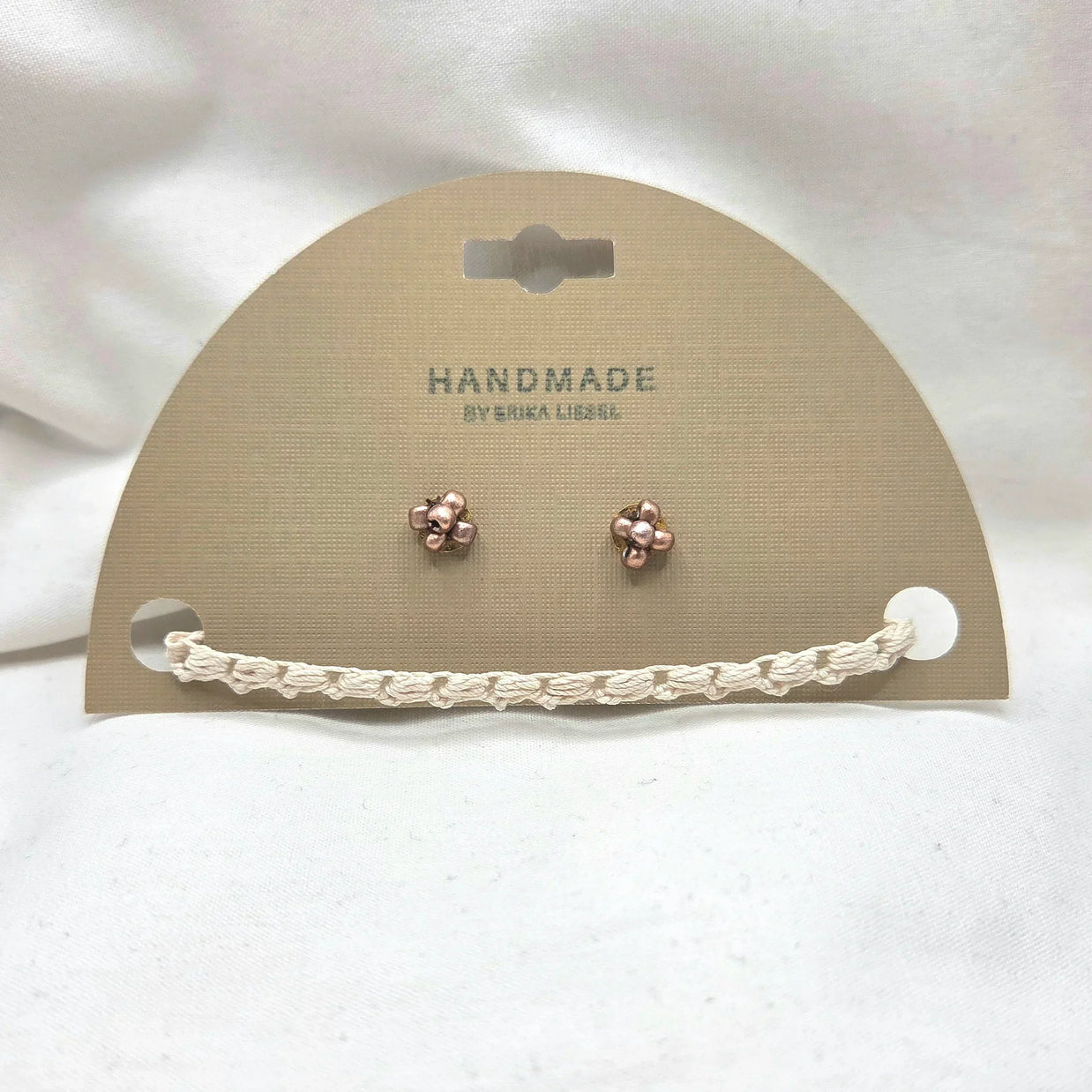 Handmade copper flower stud earrings with crochet chain on display card