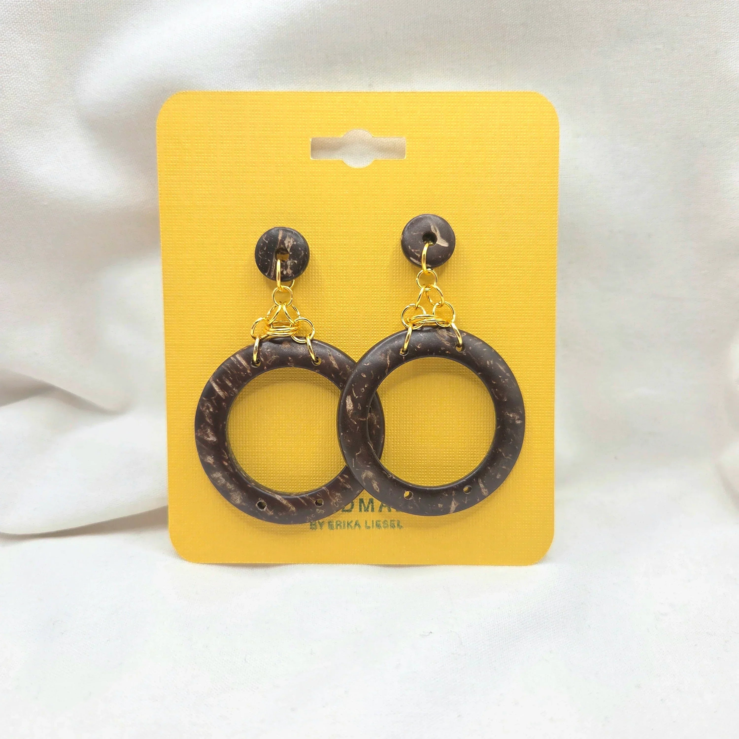 Coconut shell hoop earrings with gold chain, handmade boho jewelry on yellow display card