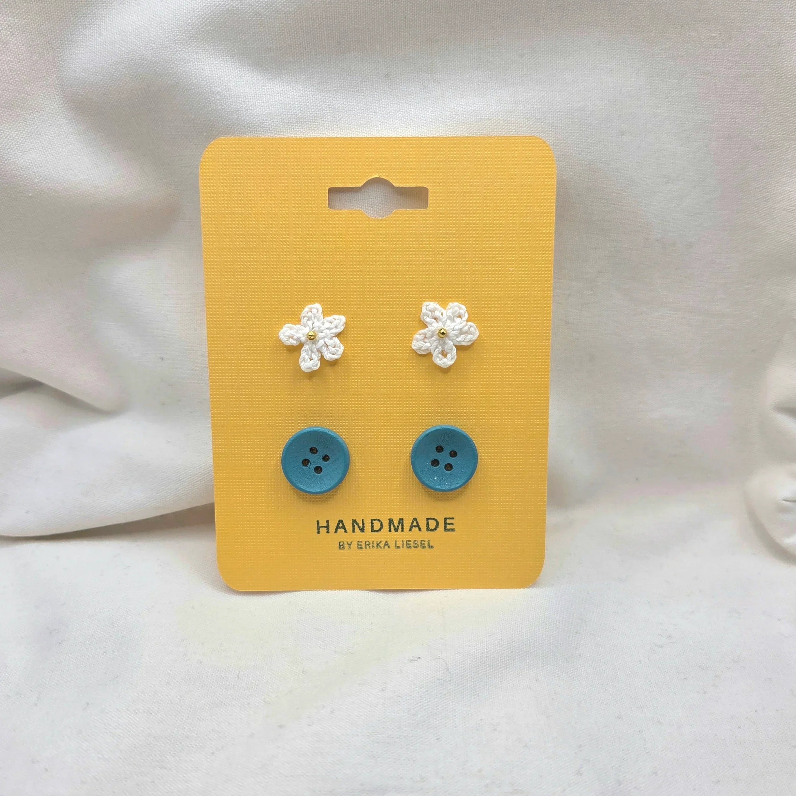 Handmade crochet flower and blue button earrings on yellow card, cozy craft gift set