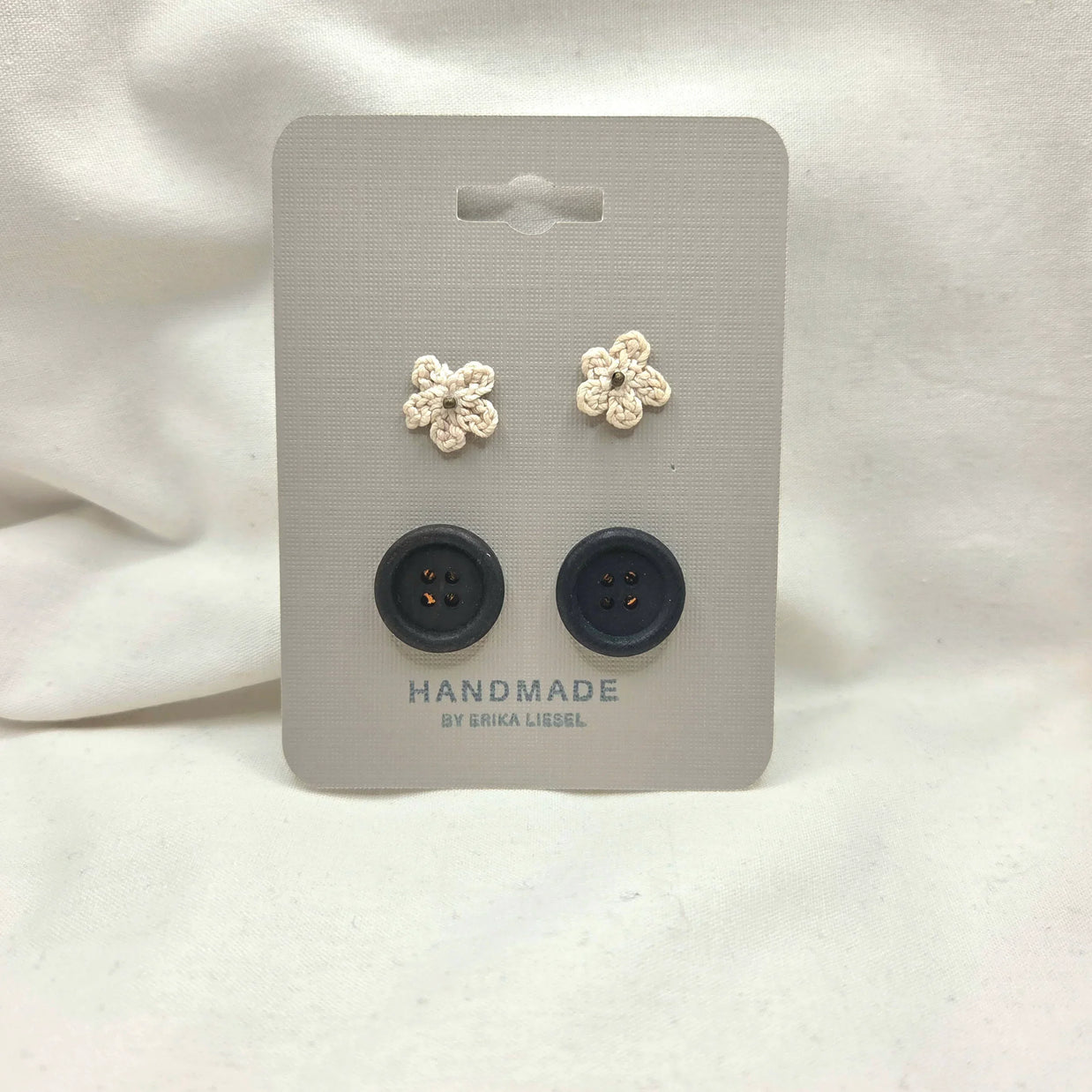 Handmade crochet flower buttons and black buttons on display card, cozy craft supplies