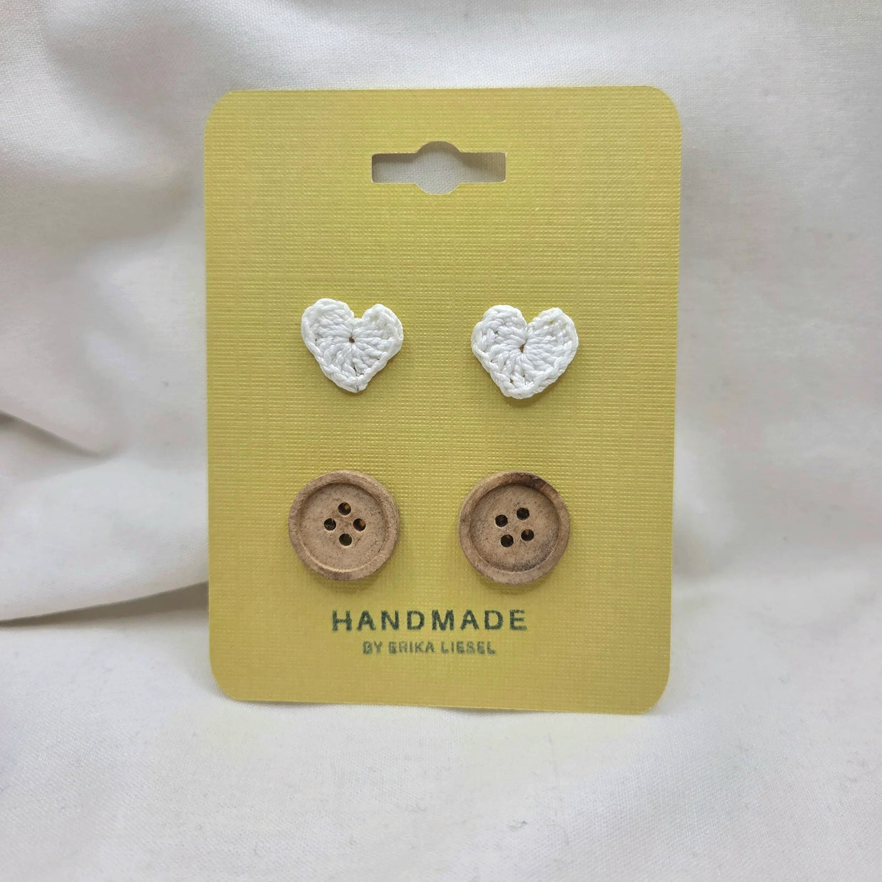 Handmade crochet heart and wooden buttons on yellow card, cozy craft supplies for DIY projects