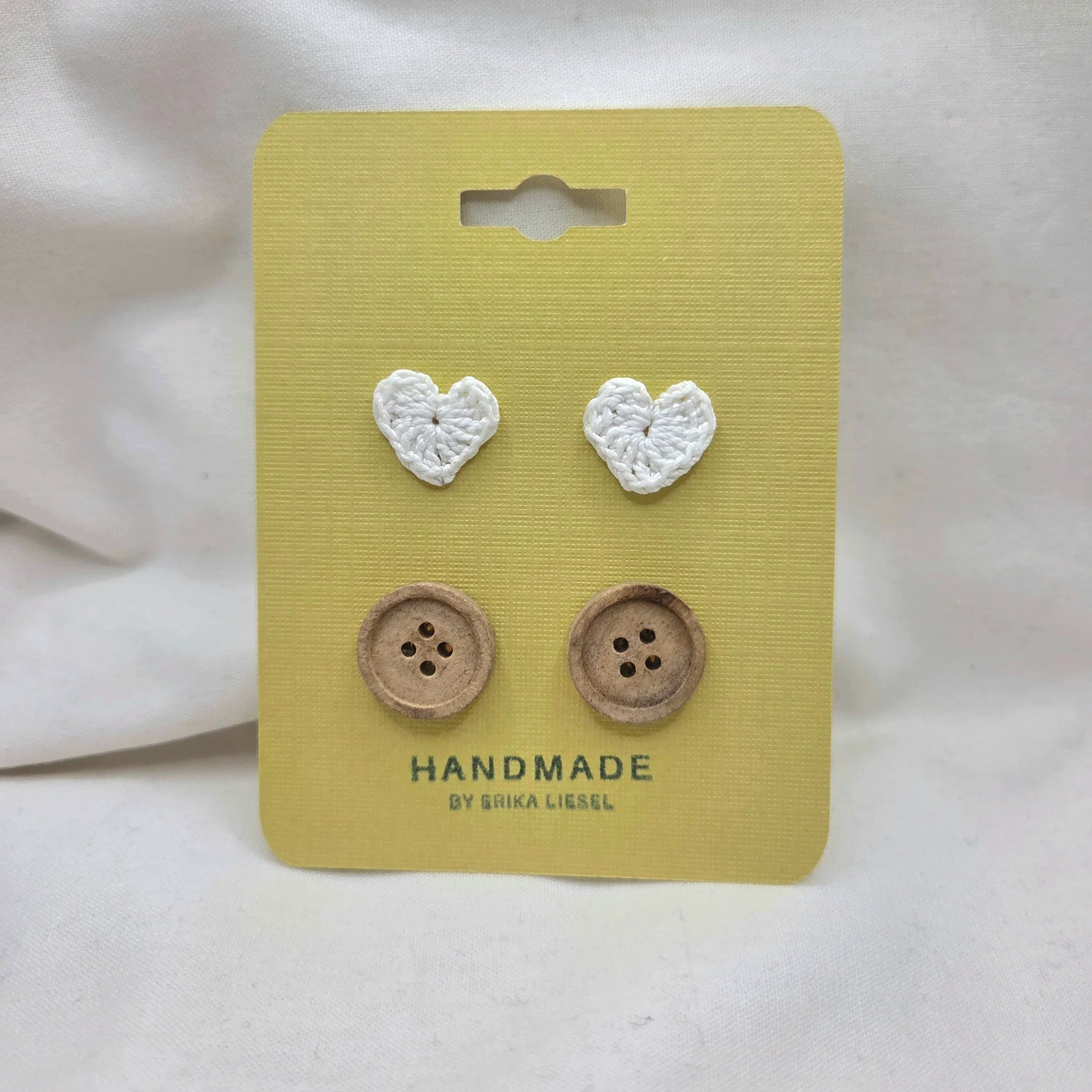 Handmade crochet heart and wooden buttons on yellow card, cozy craft supplies for DIY projects