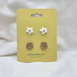 Handmade crochet flower and wooden buttons on yellow card, cozy craft supplies for DIY projects
