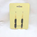 Handmade black stone dangle earrings with gold hooks on yellow card