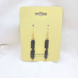Handmade black rectangular drop earrings with gold chain links on yellow display card